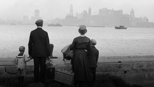 Black and white picture of an early 20th century family looking across a river in a big city.