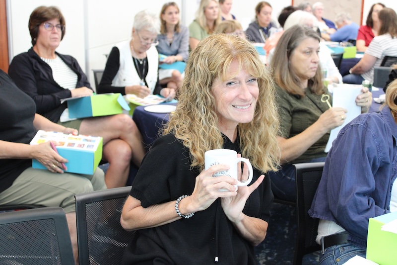 A woman smiling with a mug.