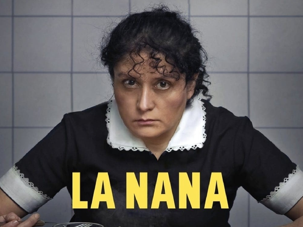 La Nana. Woman in a maid outfit starring at the camera.