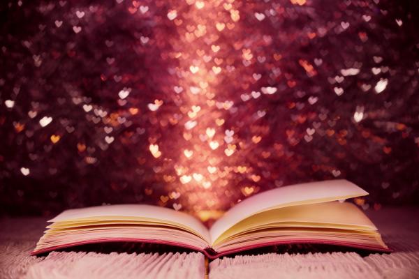 Open book with sparkly hearts emerging. 