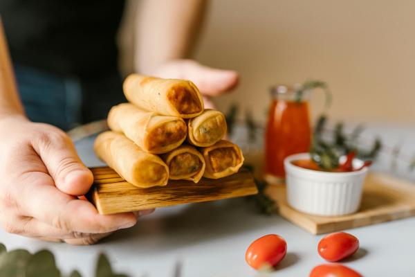 Hands holding a stack of eggrolls