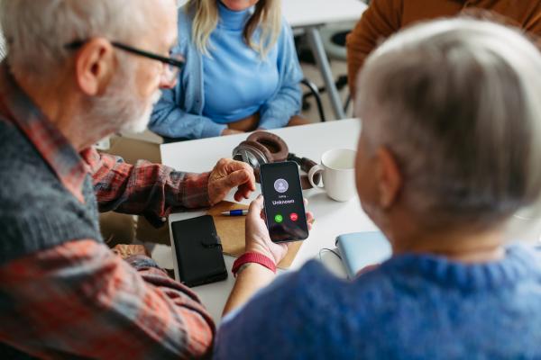 Two seniors looking at a scam call on a phone.