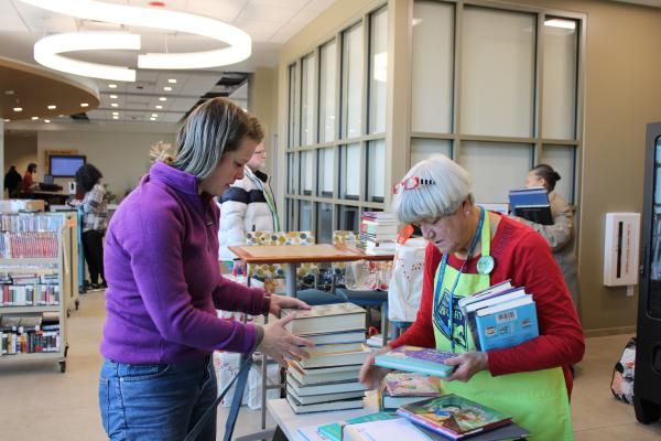 Attendee purchasing books at a book sale.