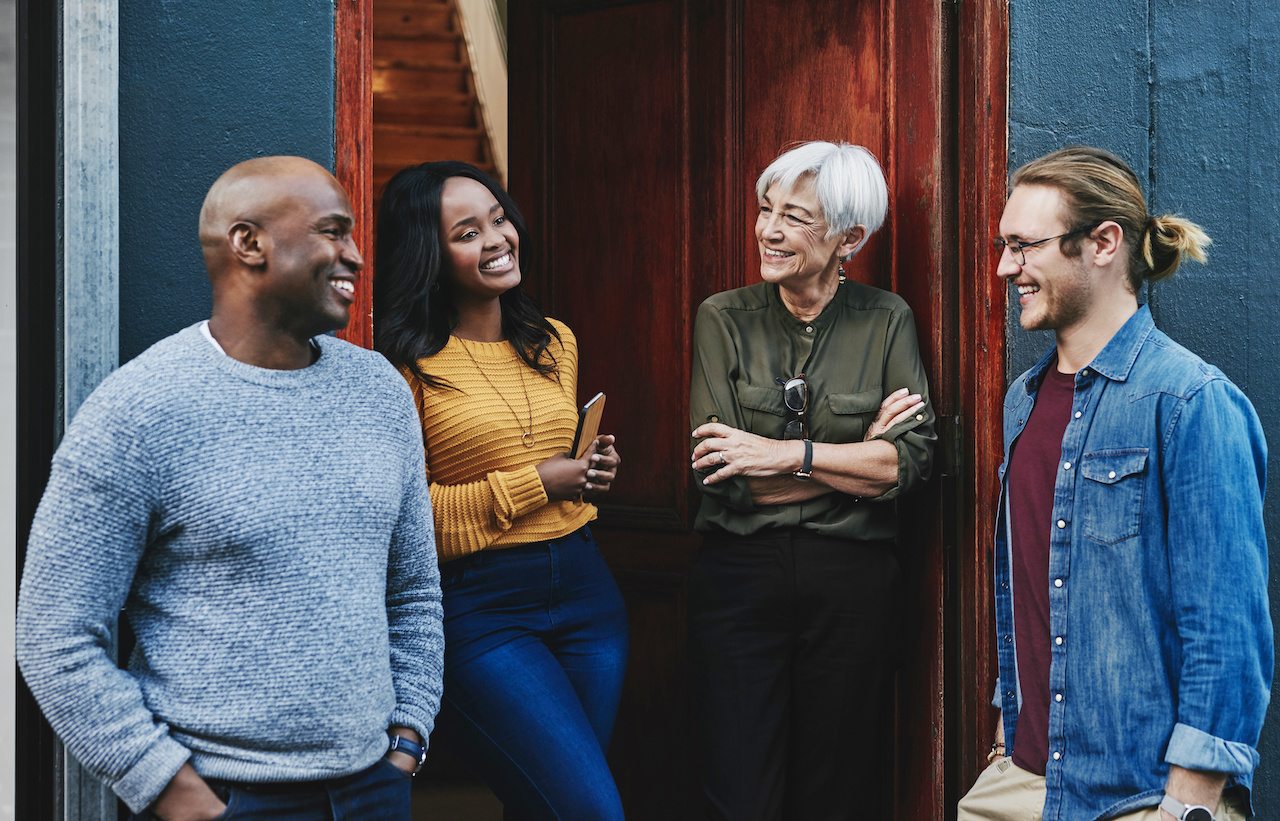 Adults smiling while discussing their work.