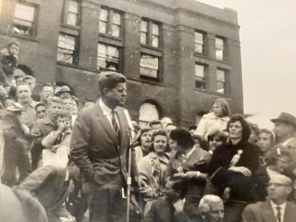John F. Kennedy on the steps of the Kane County Courthouse with a crowd.