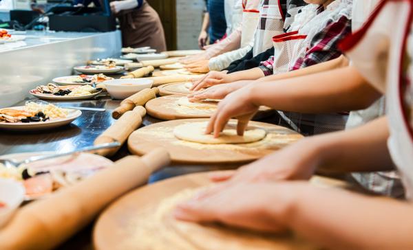 School aged children preparing pizza dough.