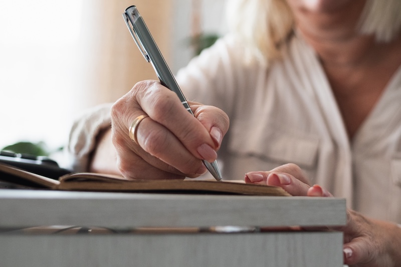 Older woman's writing in a journal