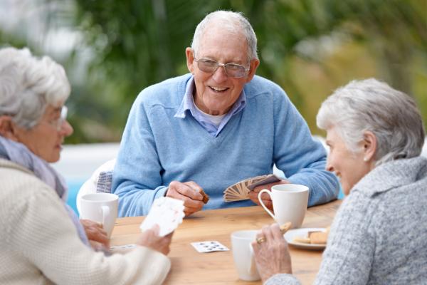 Seniors smiling while playing a card game.
