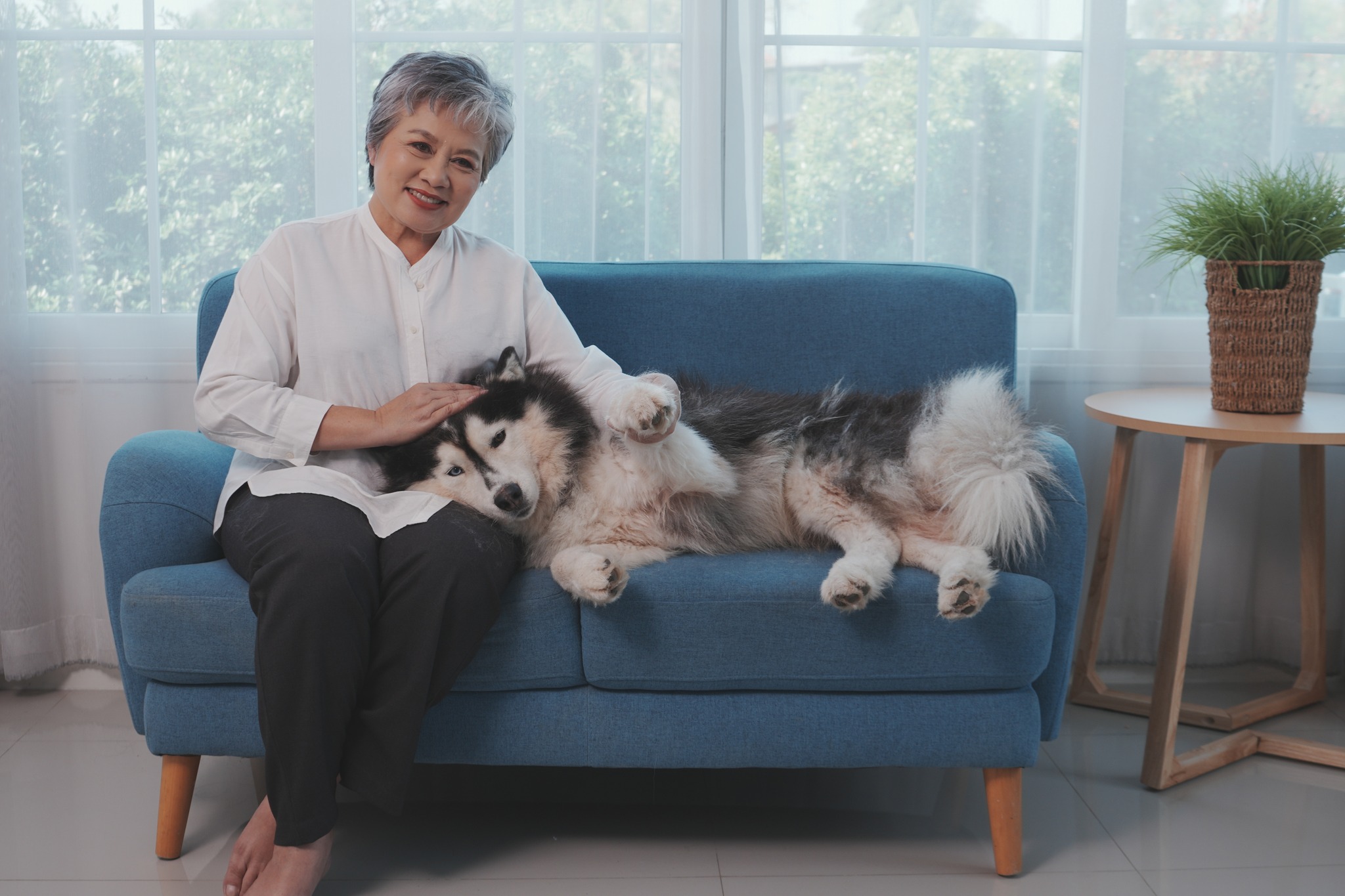 A woman and her Huskey on a couch
