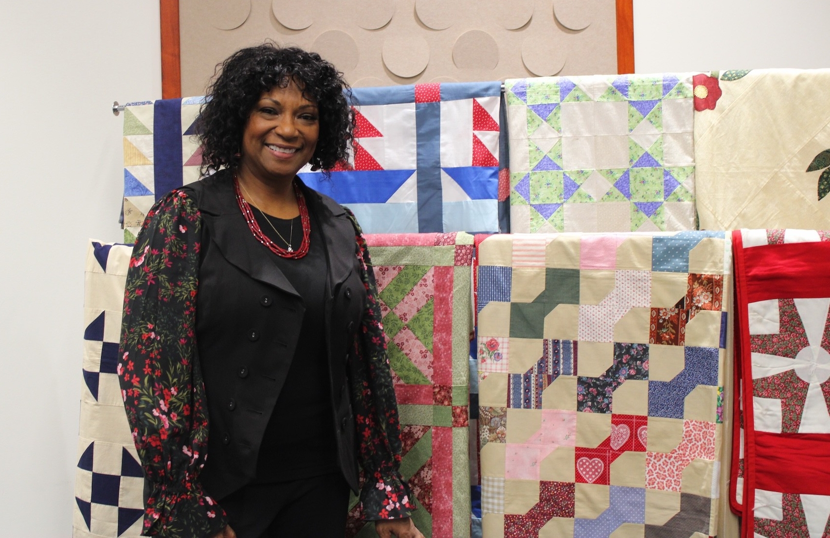 Connie Martin standing in front of a display of quilts.