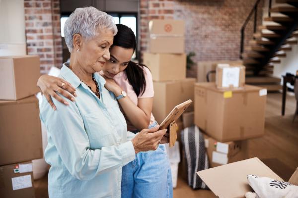 A senior and her graddaughter in a room filled with packed boxes