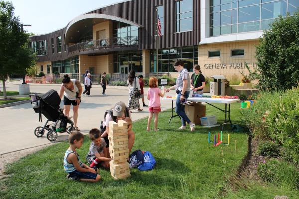 Families playing games outside the library.
