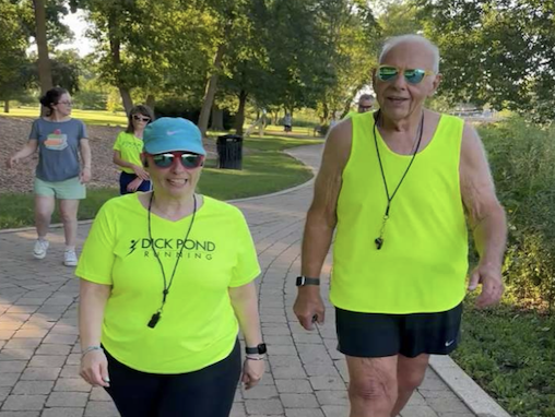 A pair of adults walking in the park.