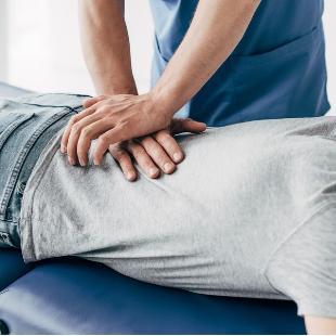 A professional massaging a client's back.
