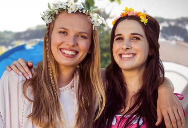 Two girls smiling while wearing flower crowns.