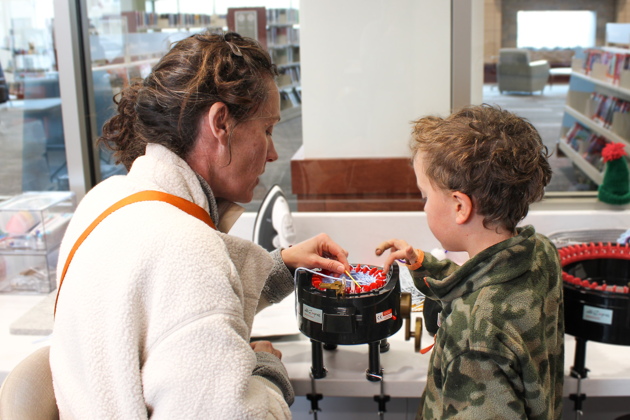 Mother and son using the knitting machine