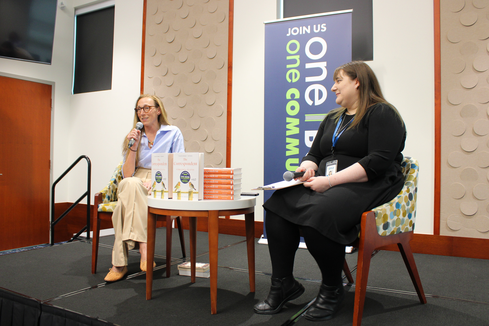 Virginia Evans sitting with event moderator